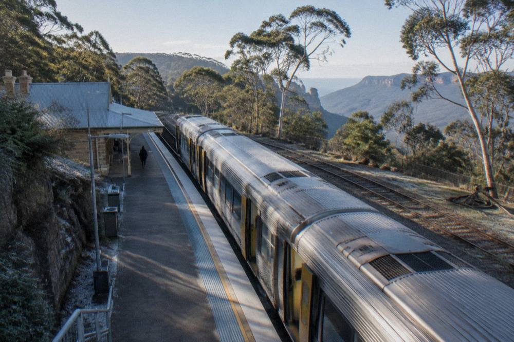 A country train waiting at a Blue Mountains station surrounded by eucalypt forest