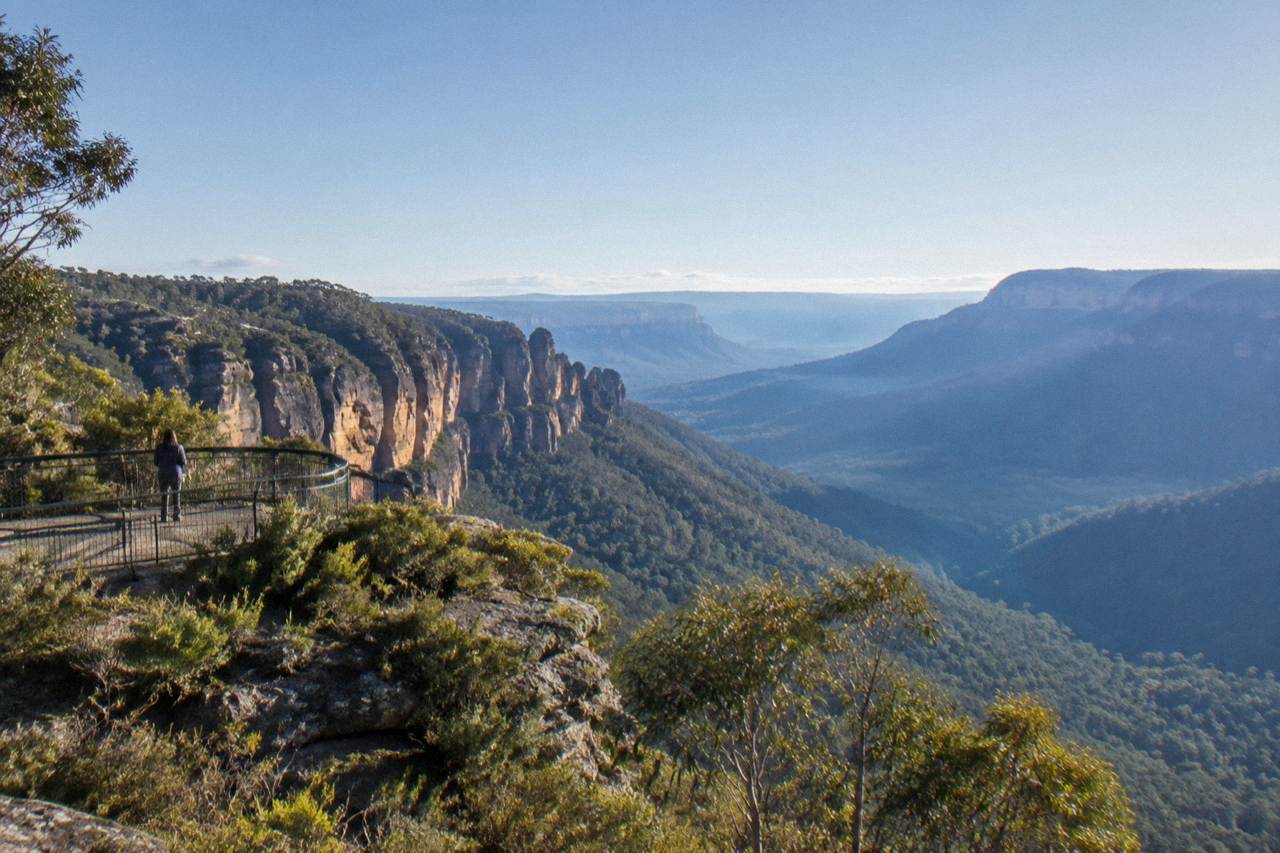 Sandstone cliffs and forested valleys of the Blue Mountains under a wide sky