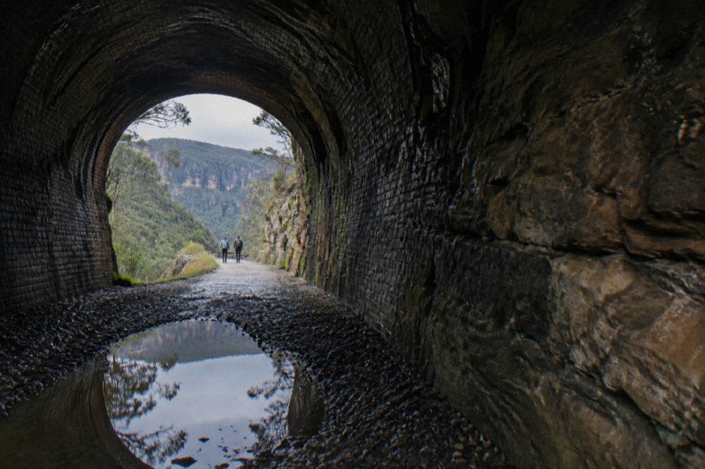A curved disused railway tunnel interior with rough stone walls