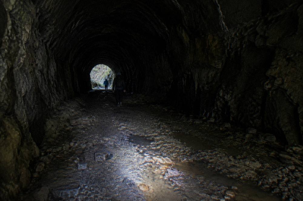 Rough uneven stone floor inside a long dark abandoned railway tunnel