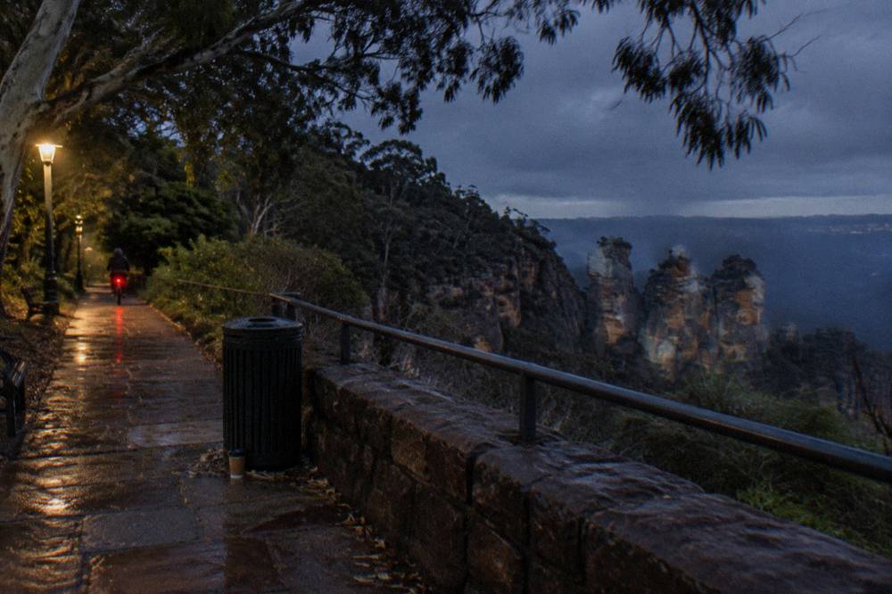 A dark bush track at night lit by a faint red headlamp glow